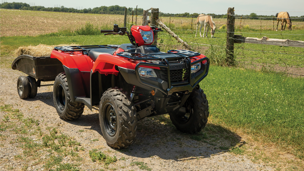 A Honda Foreman parked with a towing trailer