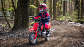 A young rider on a Honda CRF50F