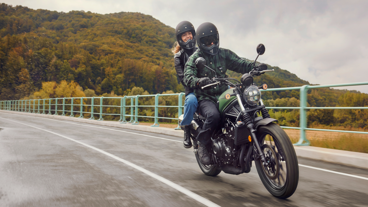 Two riders on a Honda SCL500